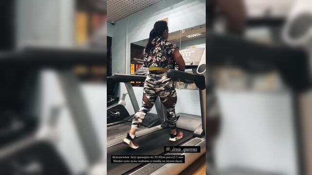 A girl with a muscular body is walking on the street