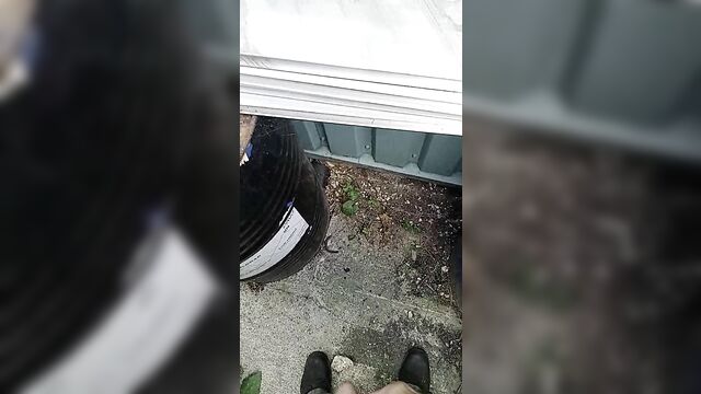 A short video of a guy peeing outside in public space