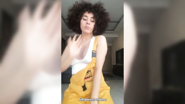 A teen with curly hair has fun while jumping and getting naked on tiktok