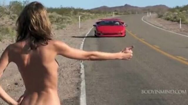 Великолепная девушка пытается поймать попутку голой